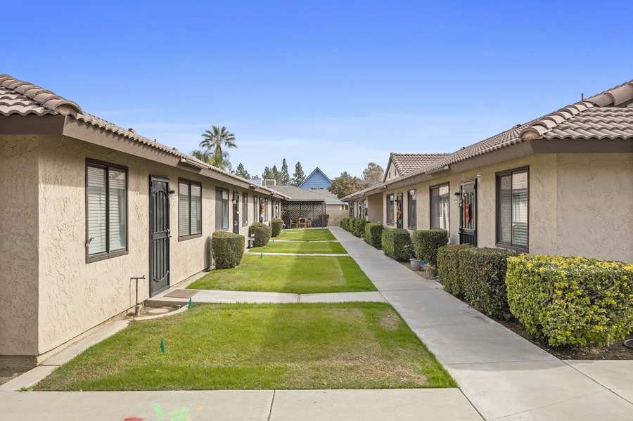 Manor III walkway between homes with trimmed hedges